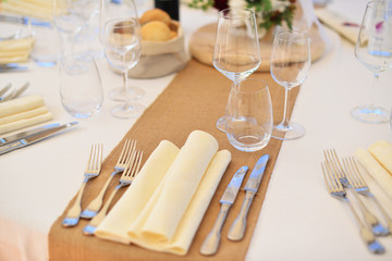 Table set up for dinner party. 
Wine glasses with white wine in a restaurant.