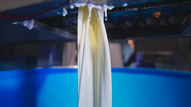 White paint is poured into a bucket, the process of pouring paint to the factories, the process of colorization in the factory