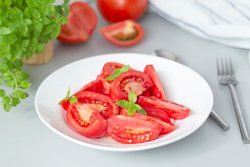Tomato salad with basil and olive oil in bowl. Selective focus