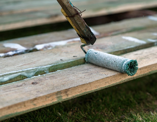 
man paints a board with a roller