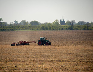 Tractor preparing a field with a roller.