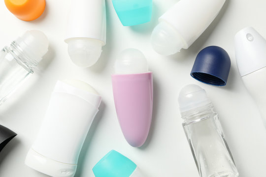 Different body deodorant on white background, top view