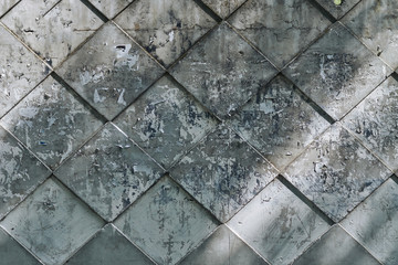 Background texture, concrete fence in the form of tiles with glue residue from torn ads.