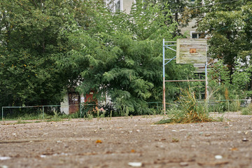 Open basketball court near an abandoned school