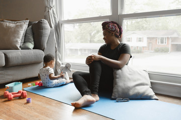 Mother watches toddler play at home during quarantine