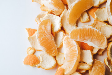 Bright slices of orange and peel on a white background close-up