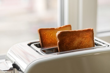 freshly baked toaster bread. A couple of crusty toasts in the toaster, close-up. delicious...