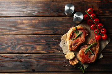 Composition with fried steaks on wooden background. Grilled food