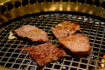 焼肉店　肉（カルビ）を焼き網の上で焼いている　