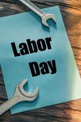 lying on wooden boards next to assembly keys, blue card with the inscription "Labor Day"