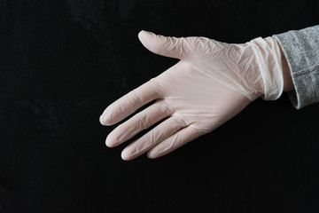 Fototapeta na wymiar A hand in a white medical glove, extended to shake hands. Greeting, greeting, security and protection concept. Virus, pandemic.