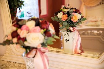wedding bouquet in a vase stolt by the mirror
