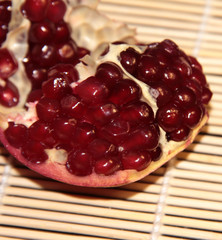 Pomegranate berries on a beige wooden background. Pomegranate.