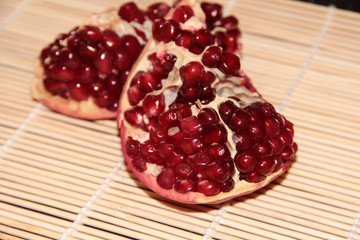 Pomegranate berries on a beige wooden background. Pomegranate.