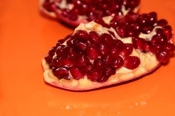 Pomegranate berries on an orange background. Pomegranate.