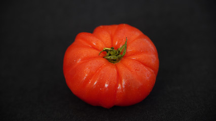 
Close-up on a beef heart tomato, on a black background