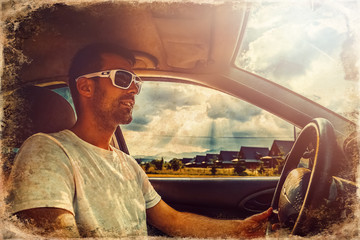 Attractive elegant happy man in a car, old photo effect.