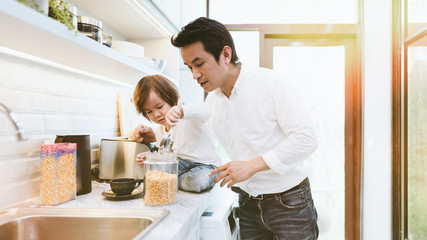 Daddy and son busy in the kitchen, fatherhood learning to be babysitter and teaching his kid for kitchen stuff while mother not in the house,  Single dad with son in the house during covid-19 crisis.