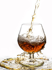 Glass with splashes from whisky on a black background