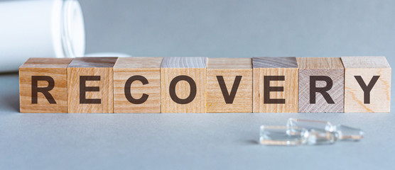 RECOVERY - words from wooden blocks with letters, feel worried and nervous stress concept, top view light background