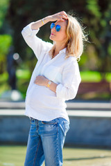 Pregnant woman in outdoor park, warm weather