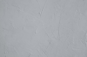 A close-up of the surface is gtey with plaster texture. Horizontal orientation, selective focus. 