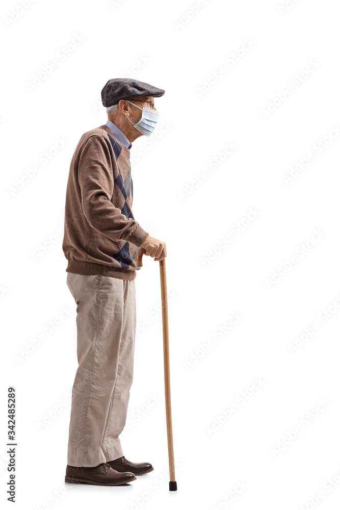 Wall mural Senior man with a cane wearing a medical mask