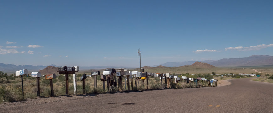 A Long Row Of Mail Boxes Leads Down A Road