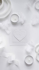 Flat-lay Braille valentine card with feathers, ribbons