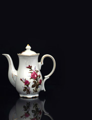 teapot with flowers on black background