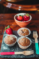 Appetizing Chocolate Muffins made with wholemeal flour and brown sugar with strawberries for a healthy breakfast.