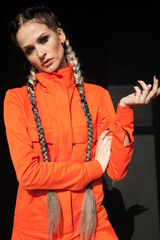 Portrait of a beautiful woman with braids in orange clothes