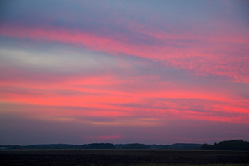 Nightfall in the country: red clouds over a dark horizon