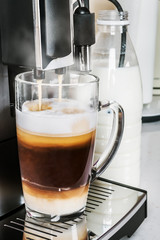 flavorful natural cappuccino made in a coffee machine. glass glass with hot drink with cappuccino foam
