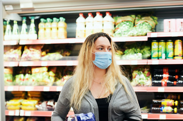 Woman buying food in grocery store, wearing medical mask