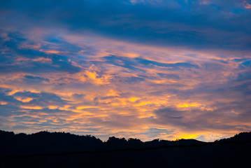 Dramatic clouds in the sky at sunrise in rural Guatemala, silhouette of mountains, forest area.

