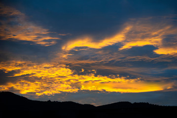 Dramatic clouds in the sky at sunrise in rural Guatemala, silhouette of mountains, forest area.

