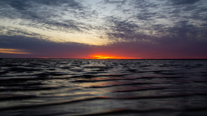 Red sunset on the beach. The clouds. Landscape.