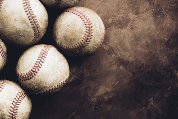 Old vintage brown texture background with copy space by used and worn sports baseballs close up.