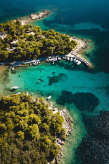 Bateaux au port sur une plage de méditerranée sur l'île de Rab en Croatie par drone