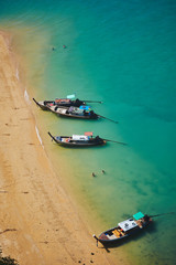 Traditional long tail Thai boats parked on Beautiful beach with a white sandbar and blue sea at Koh...