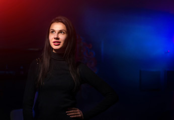 Naklejka premium Beautiful woman looking at side holding hand on waist. Blue light background.