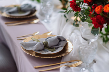 wedding table, red flowers, dishes. decorated table for a wedding