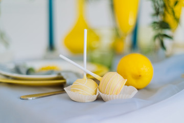 yellow cakes and lemons on a table covered with a blue tablecloth