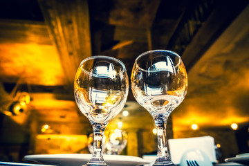 The served table in the restaurant. Clean dishes and appliances on the tablecloth in a cafe. Shiny transparent glasses. White plates. Prepared for the reception of guests. High service.