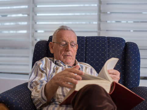 Old Man Reading Book At Home