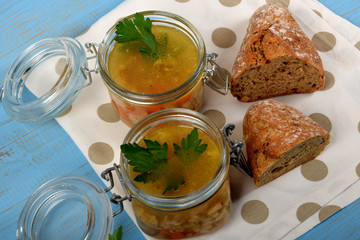 tripe soup in glass jars with fresh green parsley next to bread