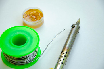 Soldering iron, tin, rosin on a white background. Soldering iron in male hands. Macro. Repair of...