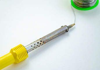 Soldering iron, tin, rosin on a white background. Soldering iron in male hands. Macro. Repair of...