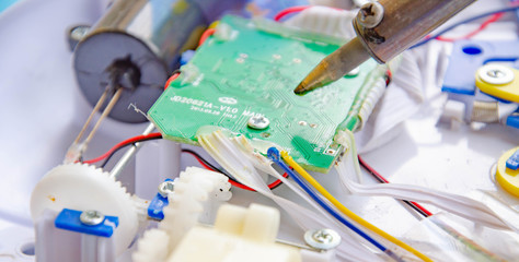 Soldering iron, tin, rosin. Soldering iron in male hands. Macro. Repair of electrical equipment,...